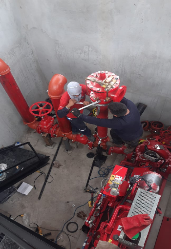 Instalación de válvula contra incendios. Dos técnicos trabajando en la tubería.