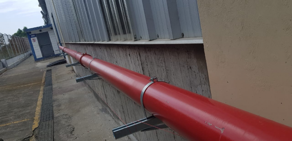 Tubería roja de gran diámetro montada en exterior.